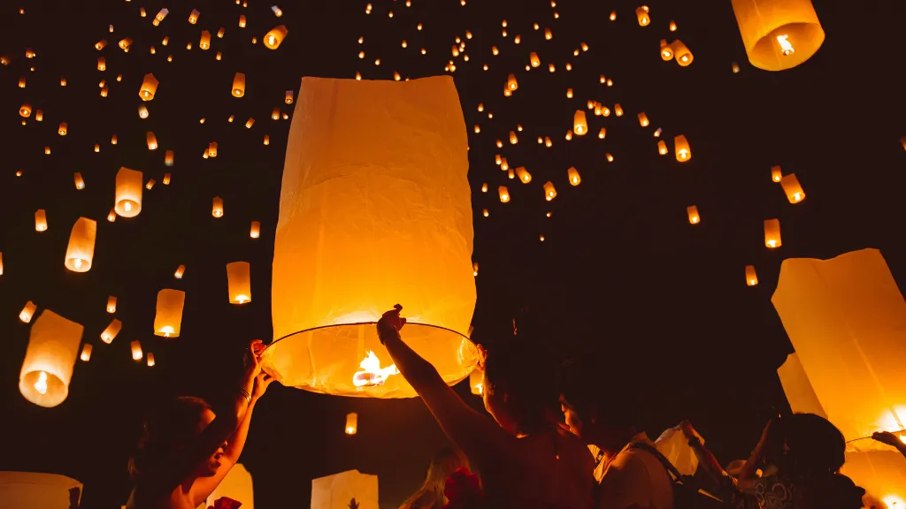 People releasing sky lanterns during the beautiful Loy Krathong or Yi Peng festival in Thailand. 
