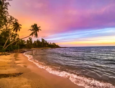 Stunning tropical beach sunset in Thailand with palm trees and turquoise waters — curated by a luxury Thailand DMC and tour operator