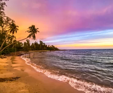 Stunning tropical beach sunset in Thailand with palm trees and turquoise waters — curated by a luxury Thailand DMC and tour operator