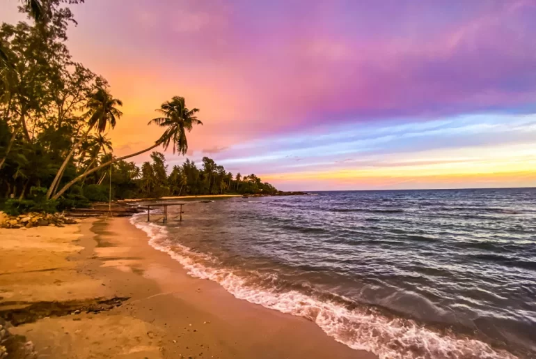 Stunning tropical beach sunset in Thailand with palm trees and turquoise waters — curated by a luxury Thailand DMC and tour operator