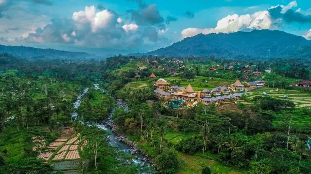 Aerial view of Wapa di Ume Sidemen, a luxury resort tucked into the river valley and working rice terraces of eastern Bali — far from the crowds of Ubud, in the island's most unspoiled highland landscape