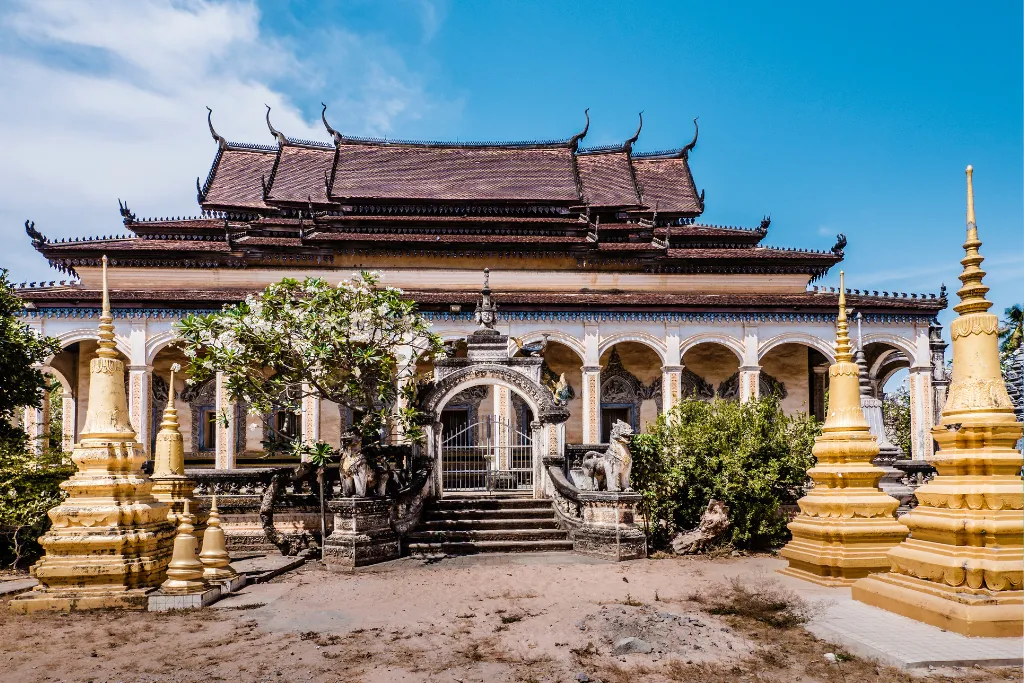 Serene Cambodian pagoda with traditional architecture and golden stupas, offering a glimpse into cultural immersion for luxury travelers and MICE groups.