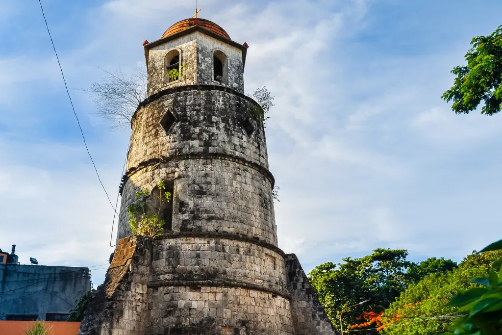 The historic Dumaguete Bell Tower, a prominent landmark with rich cultural heritage, under a clear sky. Essential for cultural tours and providing a glimpse into the city's past for luxury travelers and MICE groups interested in local history.