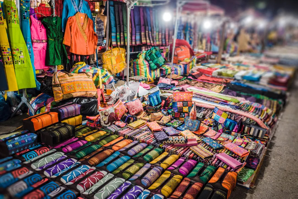 Vibrant display of handmade textiles and local crafts at the Luang Prabang Night Market, offering unique souvenirs for luxury travelers and MICE attendees in Laos.