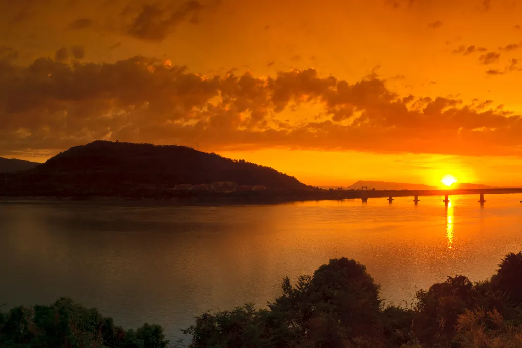 Breathtaking golden sunset over the Mekong River in Pakse, Laos, perfect for luxury cruise experiences, romantic getaways, and scenic backdrops for MICE events.