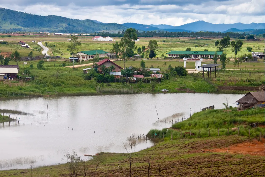 Picturesque village scene with traditional homes and a tranquil lake in Phonsavan, Laos, highlighting authentic experiences for luxury travelers and DMC operations.