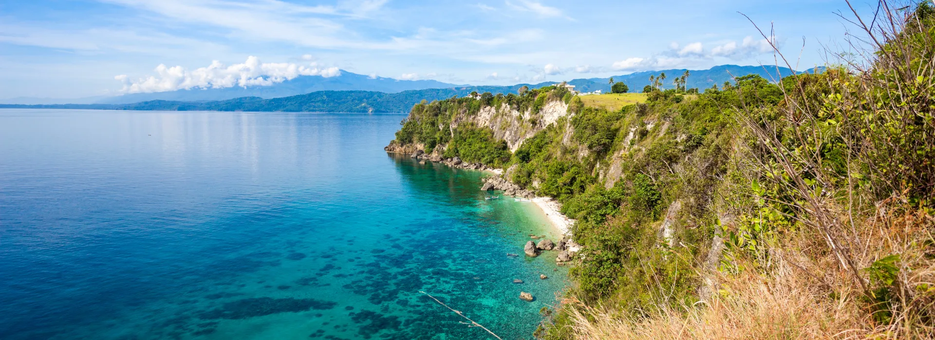 Scenic coastline of Puerto Galera, Philippines, showcasing turquoise waters and lush hills for corporate travel and DMC incentive trips.