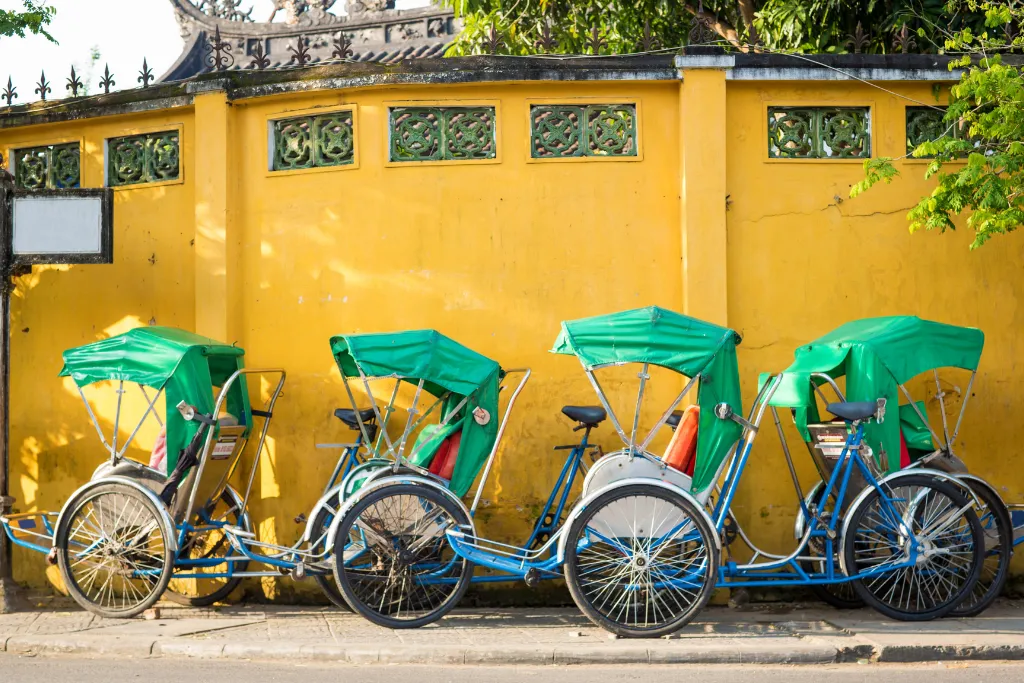 Traditional cyclos (rickshaws) lined up in Hoi An, offering a unique and authentic luxury transportation experience for group tours and bespoke itineraries.