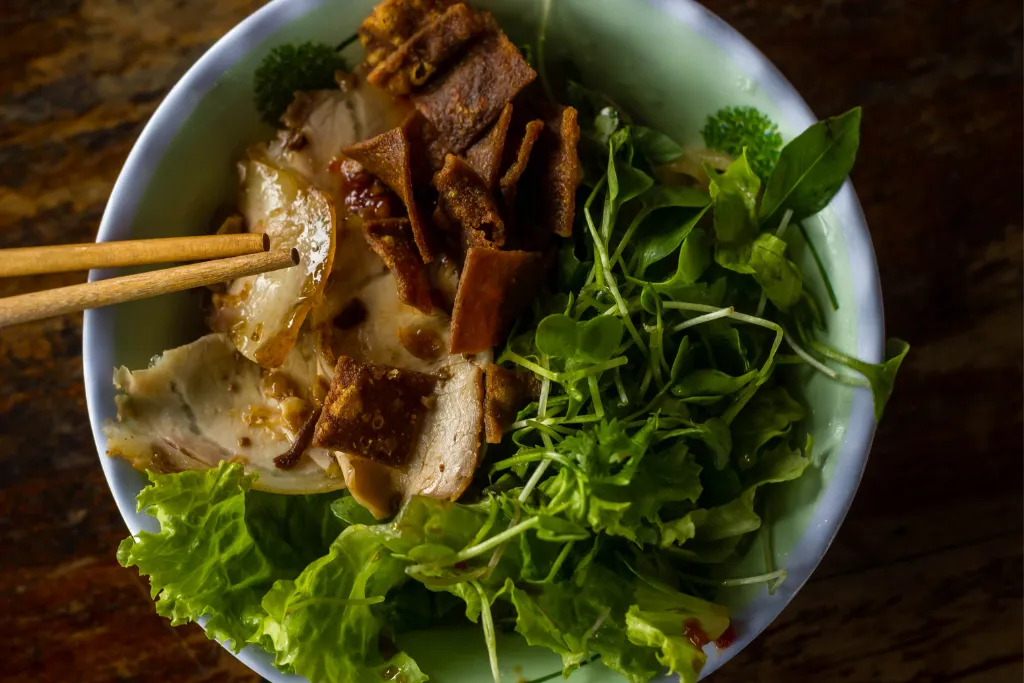A close-up of delicious Mi Quang noodles, a local specialty of Hoi An, representing the authentic culinary experiences offered on luxury food tours and MICE programs.