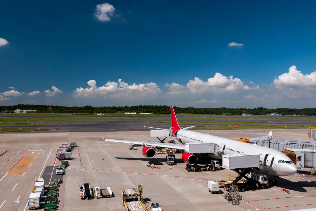 An airplane parked at a gate at Narita Airport in Japan, symbolizing a seamless and luxurious start to an international corporate travel or MICE event.