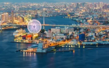 A stunning aerial night view of Osaka Harbor, featuring the Ferris wheel, ideal for luxury incentives and Japan group travel.