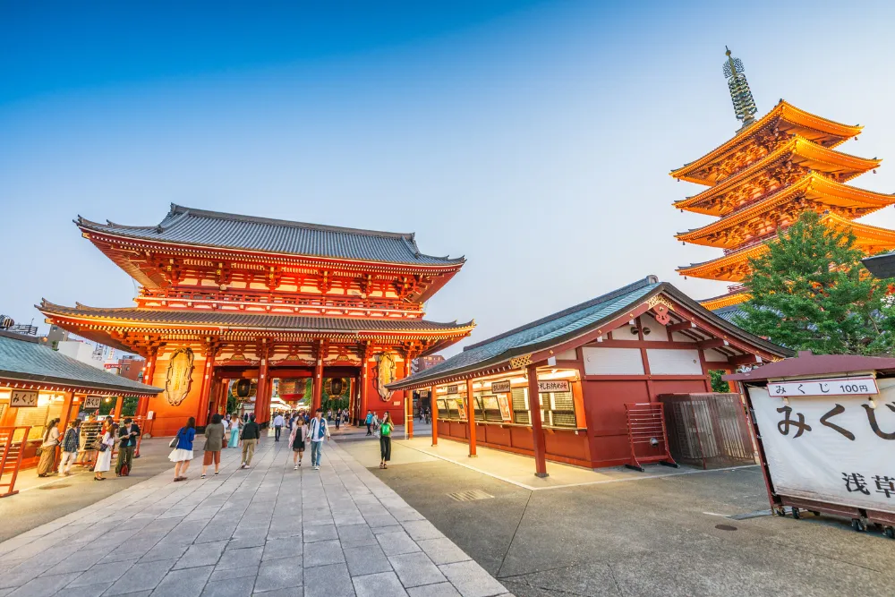 A stunning photo of the iconic Senso-ji Temple in Tokyo at dusk, showcasing its red pagoda and main hall. This image represents the traditional culture and high-end tours available in Japan.