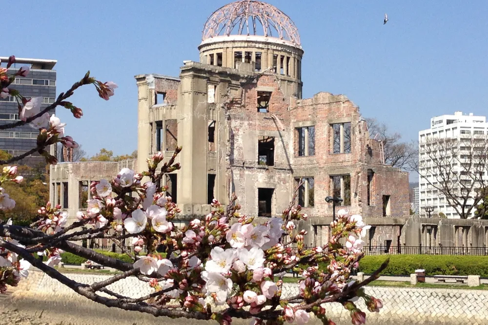 The iconic Genbaku Dome (Atomic Bomb Dome) in Hiroshima framed by beautiful cherry blossoms. A powerful and peaceful symbol, this UNESCO World Heritage Site is a key stop on our luxury tours and Japan DMC itineraries.