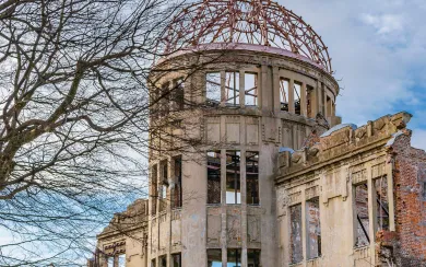 The preserved Genbaku Dome (Atomic Bomb Dome), a UNESCO World Heritage site, framed by a leafless tree in winter. This powerful symbol of peace is an essential stop on our exclusive Japan DMC and luxury tours.