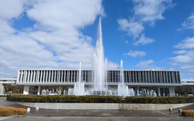 The Hiroshima Peace Memorial Museum building with a large fountain in the foreground, a poignant site for reflection. We include this important landmark in our tailored corporate and MICE travel programs for a meaningful and educational experience.