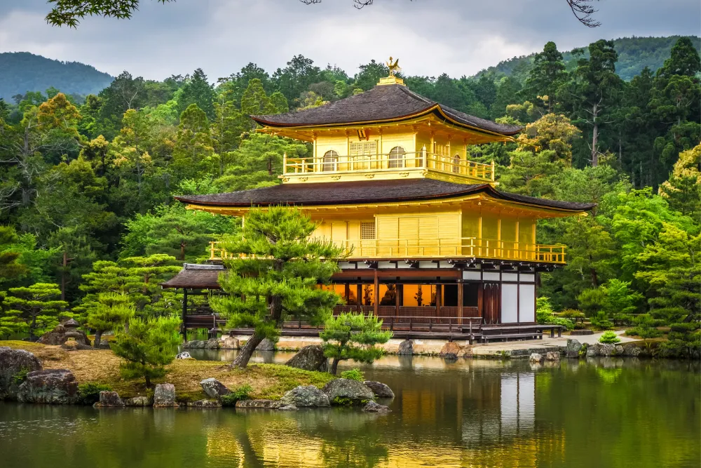 The iconic Golden Pavilion (Kinkaku-ji) in Kyoto, with its golden facade reflecting on the surrounding pond. This image highlights cultural and historical tours for a luxury experience in Japan.
