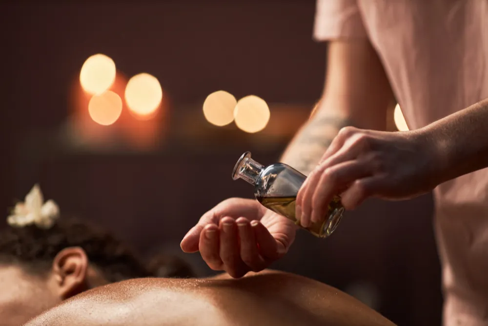 A relaxing massage at a luxury spa in Cambodia, with a therapist pouring warm oil onto a client's back. Ideal for wellness and relaxation travel.