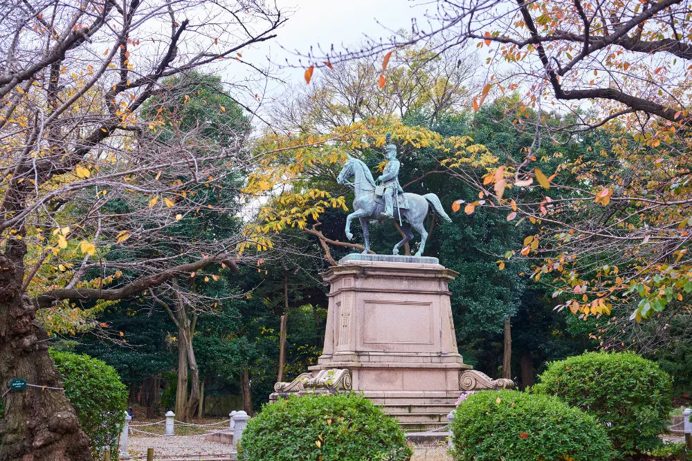 A statue of Saigo Takamori in Ueno Park, Tokyo, surrounded by trees with autumn foliage. This image highlights the historical and cultural tours available on a luxury trip to Japan.