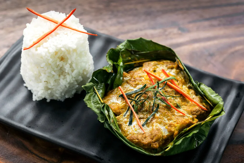 Delicious Cambodian Amok fish curry steamed in a banana leaf, a highlight of bespoke Cambodia culinary tours. Experience authentic Cambodia travel and fine dining with our luxury Cambodia DMC.