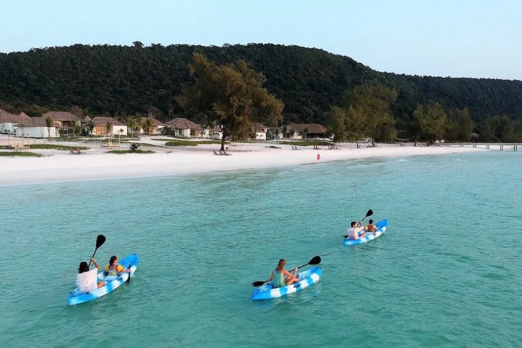 Exclusive Cambodian island resort with guests kayaking. Discover the pristine beaches and luxury stays on your bespoke Cambodia tours and Cambodia holidays.