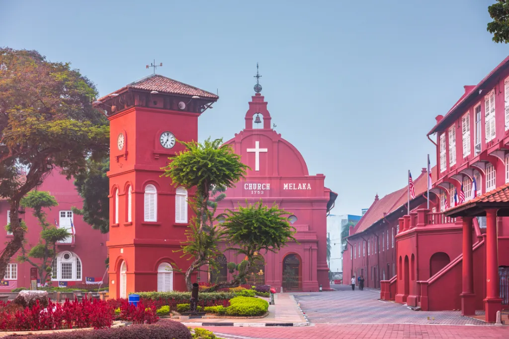 Iconic red Dutch Square buildings in Malacca (Melaka), Malaysia, featuring Christ Church and the clock tower. Perfect photo for a luxury Malaysia DMC travel itinerary or exclusive Malaysia tours and holidays.