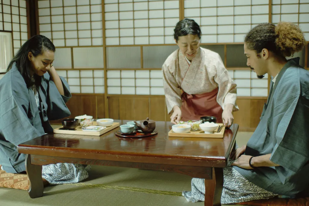 Guests wearing yukata enjoying an authentic ryokan meal, showcasing personalized Japanese hospitality.