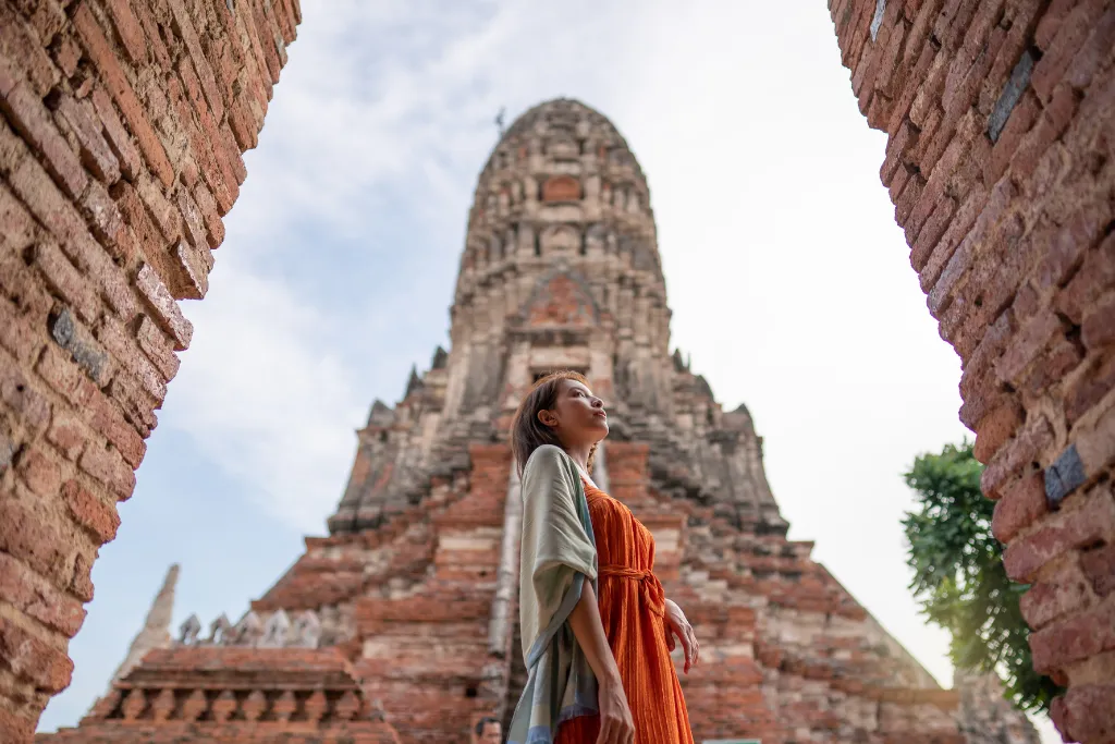 Woman exploring the ancient ruins of Wat Chaiwatthanaram in **Ayutthaya Historical Park**, a must-see for **Thailand history tours**. Experience cultural **Thailand travel** and discover UNESCO World Heritage Sites on your **Thailand holidays** planned by our **Thailand DMC** specialists.