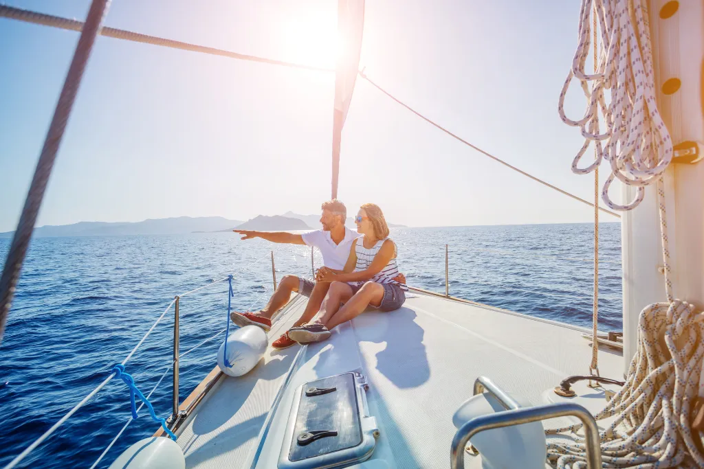 A happy couple relaxing on the deck of a luxury sailing yacht on a private Thailand tour. Ideal for premium Thailand holidays and bespoke Thailand travel packages offered by a Thailand DMC.