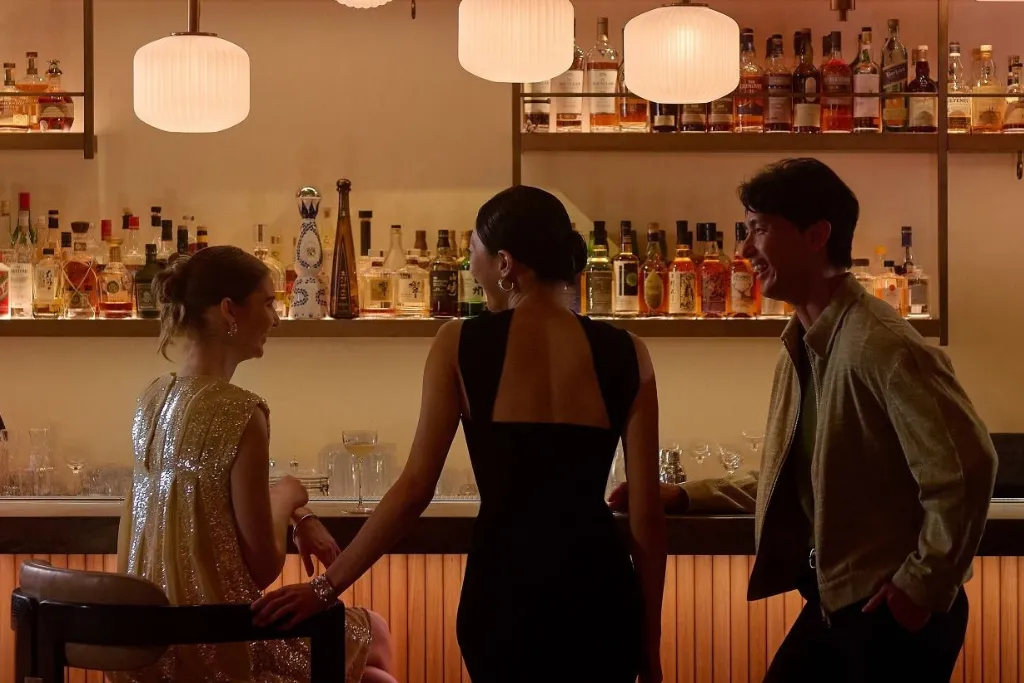 Guests enjoying cocktails and the vibrant nightlife scene at a stylish luxury bar in Singapore.