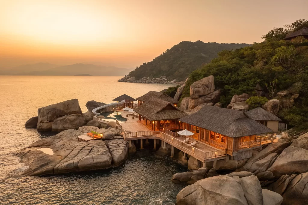 Breathtaking sunset view of an overwater private villa at a **Six Senses Vietnam luxury resort**. Book **exclusive holidays** and the perfect **Vietnam honeymoon** experience with our selection of top-tier accommodations.