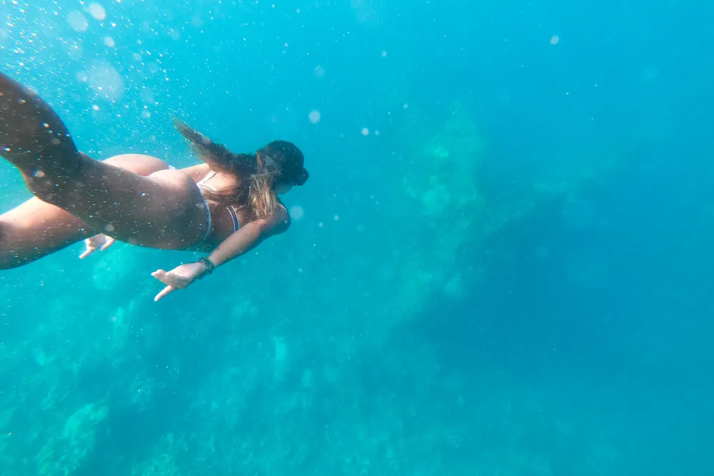 A woman snorkeling in the clear turquoise waters of Coron, Palawan during a custom island tour by Discovery DMC.