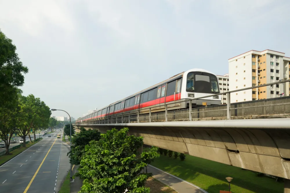 Singapore's MRT train on an elevated track passing HDB residential flats